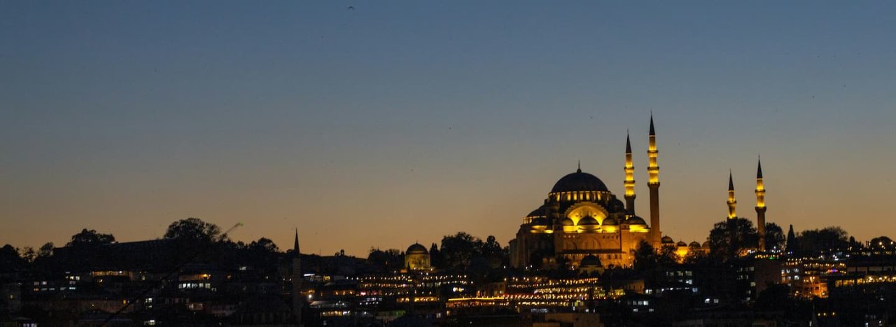 A blue hour night scene of an illuminated mosque, representing All Nations' course on Contextual engagement with Islam.