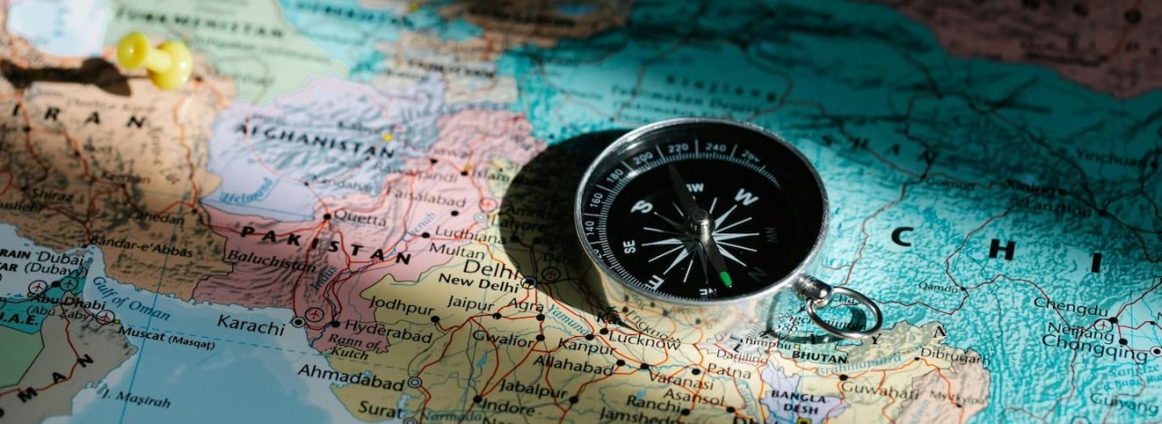 A compass on a map of the world (showing mainly central Asia), representing All Nation's vision and mission) of reaching different countries and ethnicities with the gospel and the truth of the Biblen.