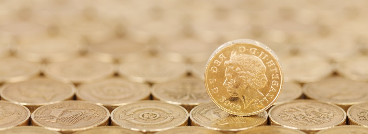 A pound sterling coin placed upright over a series of other pounds coins, representing the part that that be increased in a donation through Gift aid.