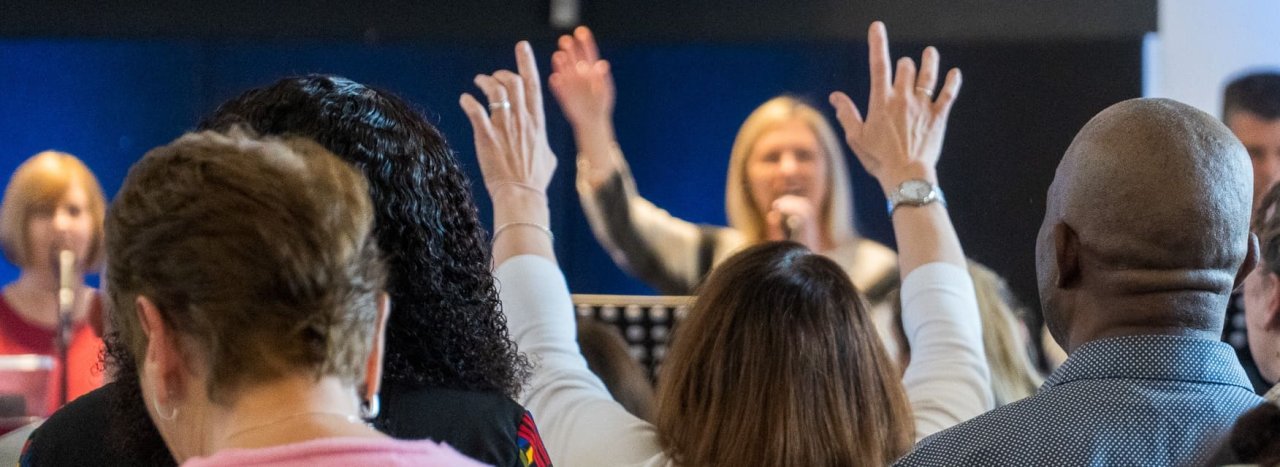 A local lively and active church showing people worshipping God with their hands lifted up, representing the variety of churches that partner with All Nations.
